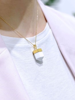 Naszyjnik z białym kwarcem, złota oprawa, minimalistyczny styl.