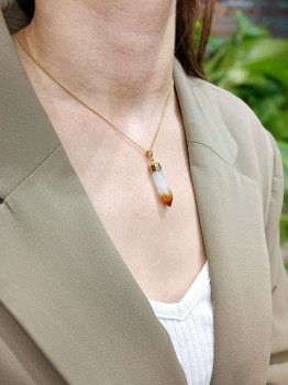 Złocony naszyjnik z cytrynem obeliskiem prezentowany na modelce, biżuteria naturalna Brazi na dekolcie.