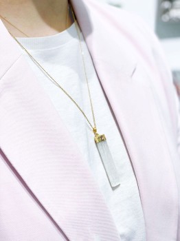 Naszyjnik z dużym surowym selenitem w złoconej oprawie prezentowany na modelce, biżuteria Brazi.