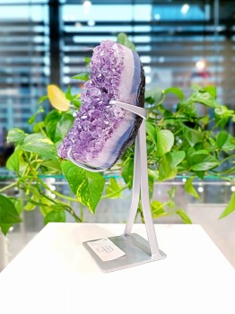 Szczotka ametystu na czarnej metalowej podstawce, surowy minerał z widoczną warstwą skalną, biżuteria Brazi