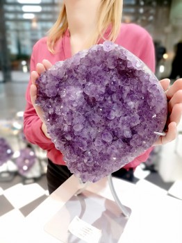 Szczotka naturalnego ametystu trzymana w dłoni, zbliżenie na gęstą strukturę kryształów, Brazi.