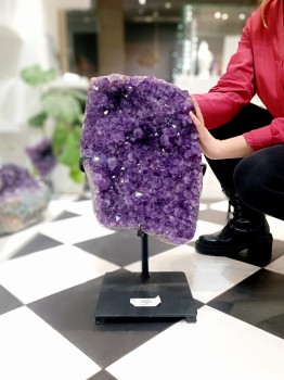 Świecznik z naturalnego obsydianu z zapaloną świecą typu tealight na białym tle, marka Brazi.