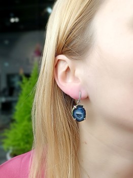 Kolczyki z niebieskim agatem meksykańskim prezentowane na uchu modelki, biżuteria Brazi