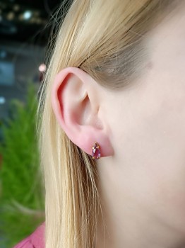 Kolczyki z naturalnym ametystem w szlifie łezki i złoconej oprawie na uchu modelki, biżuteria Brazi