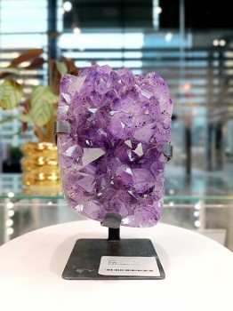 Fioletowa szczotka ametystu Brazi Druse Jewelry na podstawce.