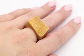 Pierścionek z naturalną druzą agatu w kolorze rudym prezentowany na dłoni modelki, marka Brazi