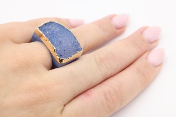 Złocony pierścionek z błękitnym agatem druzą prezentowany na dłoni, naturalna biżuteria marki Brazi.