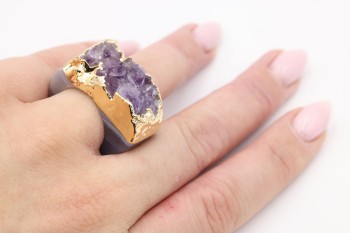 Pierścionek z fioletową druzą ametystu i złoceniem prezentowany na dłoni, marka Brazi