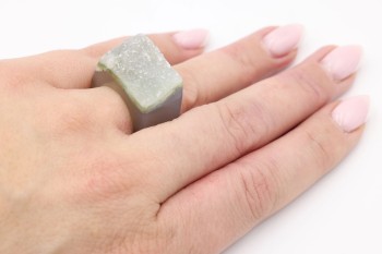 Pierścionek z naturalną druzą agatu w kolorze zielonym prezentowany na dłoni, biżuteria Brazi.