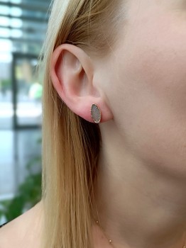 Kolczyki z szarym agatem druzą w złoconej oprawie prezentowane na uchu, biżuteria Brazi