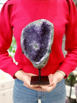 Szczotka ametystu z Urugwaju trzymana w dłoniach dla porównania wielkości, naturalny kamień Brazi.