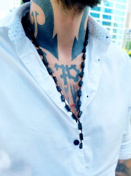 Męski naszyjnik z czarnym turmalinem na szyi modela w białej koszuli, biżuteria Brazi