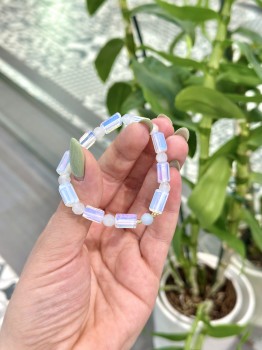 Zbliżenie na bransoletkę z opalitem w formie walców i kulistym akwamarynem ze złotymi przekładkami, biżuteria Brazi.