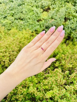 Elastyczny pierścionek z kamieni naturalnych na dłoni, tło zielonej roślinności, biżuteria Brazi