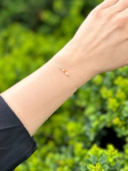 Bransoletka na jasnym sznurku z kolorowymi kamieniami naturalnymi, kontrast na tle zieleni, biżuteria Brazi