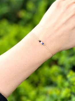 Bransoletka z minerałów na nadgarstku w świetle dziennym, zbliżenie na tle zieleni, biżuteria Brazi