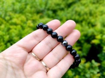 Bransoletka z naturalnego turmalinu i hematytu trzymana w dłoni, biżuteria Brazi.