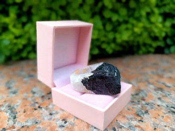 Pierścionek z turmalinem w jasnoróżowym pudełku jubilerskim na kamiennym tle, marka Brazi