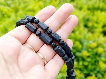 Naszyjnik z czarnego turmalinu i lawy trzymany w dłoni na tle natury, rękodzieło Brazi