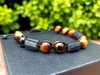 Bransoletka z tygrysim okiem i czarnym turmalinem na ozdobnym pudełku, zbliżenie na detale kamieni Brazi