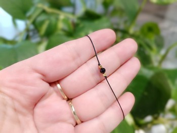 Zbliżenie na fasetowany czarny turmalin i złote koraliki w bransoletce sznurkowej, biżuteria Brazi