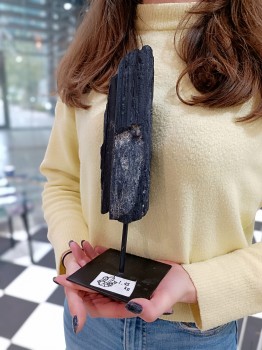 Czarny turmalin surowy na stojaku, zbliżenie na strukturę i grubość bryły, dekoracja Brazi