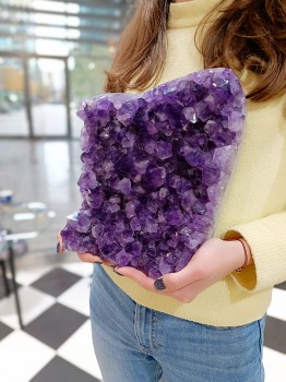 Profil szczotki ametystu trzymanej w dłoniach, widoczna naturalna struktura kamienia Brazi.