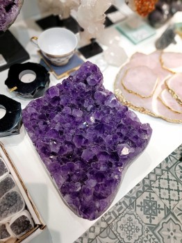 Szczotka ametystu na blacie w otoczeniu podkładek z różowego kwarcu, dekoracja Brazi.