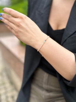 Drobna bransoletka z minerałów na nadgarstku w stylizacji z marynarką i spodniami khaki, biżuteria Brazi.