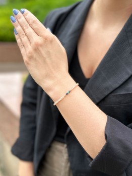 Delikatna bransoletka z kamieni naturalnych na nadgarstku modelki w scenerii zewnętrznej, biżuteria Brazi.