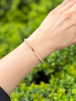 Zbliżenie na bransoletkę z kolorowymi kamieniami naturalnymi i złotymi elementami na tle liści, biżuteria Brazi