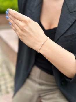 Bransoletka z minerałów jako element eleganckiej stylizacji z czarną marynarką i beżowymi spodniami, marka Brazi.