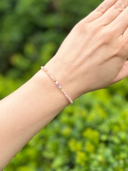 Zbliżenie na bransoletkę z fioletowym, błękitnym i białym kamieniem naturalnym na nadgarstku, biżuteria Brazi.