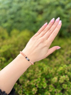 Bransoletka na gumce z drobnych kamieni naturalnych na nadgarstku modelki, ręcznie wykonana biżuteria Brazi