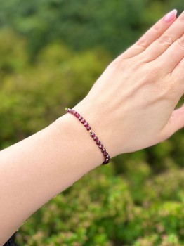 Fasetowane koraliki naturalnego granatu w bransoletce, zbliżenie na detale biżuterii Brazi.