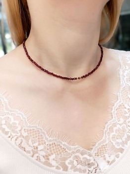 Naszyjnik z naturalnych granatów na szyi modelki, krótka kolia z ciemnoczerwonych kamieni, marka Brazi