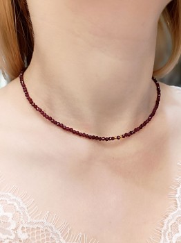 Zbliżenie na fasetowane granaty w naszyjniku z pozłacanym elementem, biżuteria z kamieni naturalnych Brazi