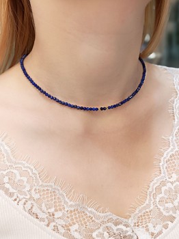 Zbliżenie na naszyjnik z naturalnego lapis lazuli o widocznej strukturze kamienia ze złotym detalem, biżuteria Brazi