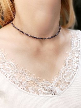 Naszyjnik z szafirów prezentowany na szyi modelki w białej bluzce, biżuteria marki Brazi