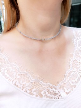 Naszyjnik z akwamarynu na szyi modelki w białej koronkowej bluzce, biżuteria marki Brazi