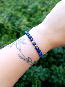 Bransoletka z naturalnego lapis lazuli na nadgarstku, fasetowana biżuteria marki Brazi.