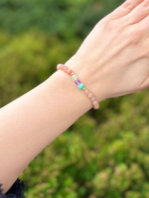 Zbliżenie na bransoletkę z fasetowanych kamieni naturalnych w kolorze brzoskwiniowym i miętowym, marka Brazi