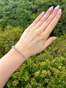 Bransoletka z ciemnego labradorytu ze złotymi detalami na dłoni modelki, biżuteria naturalna Brazi.