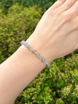 Zbliżenie na bransoletkę z fasetowanego labradorytu i złotych przekładek na nadgarstku, marka Brazi.