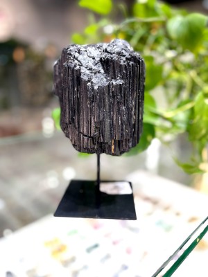 Naturalny czarny turmalin o pionowej strukturze na czarnym metalowym stojaku, dekoracja mineralna Brazi.