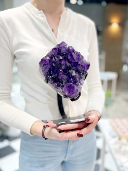 Naturalna szczotka ametystu trzymana w dłoniach, prezentacja skali dekoracyjnego minerału Brazi.