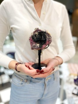 Kolorowy turmalin na podstawce trzymany w dłoniach, naturalny okaz mineralny od Brazi.