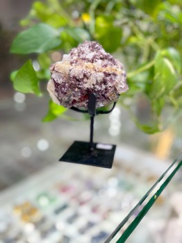 Turmalin fioletowo-biały na metalowej podstawce, dekoracja z naturalnego kamienia Brazi w aranżacji roślinnej.