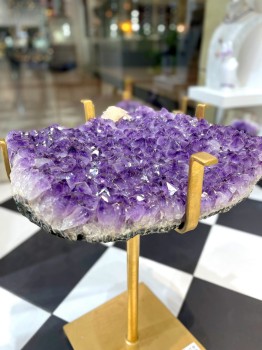 Stół z fioletowym ametystem na złotych nogach, zbliżenie na kryształy naturalnej druzy, biżuteria Brazi