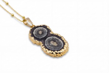 Naszyjnik z naturalnym ametystem w formie przekroju stalaktytu, złocona oprawa o nieregularnej strukturze, biżuteria Brazi.